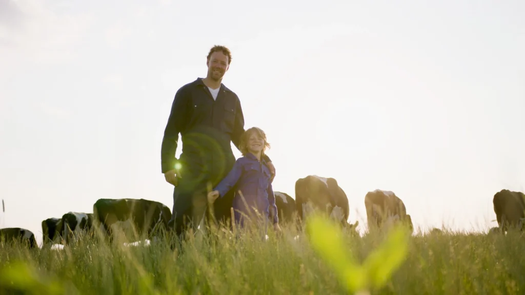 freislandcampina hero block image, farmer and son in a field with cows