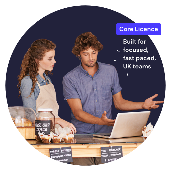 two people in a coffee shop at the counter looking at a laptop with core license highlight