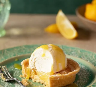 a lemon tart cake on a green plate with a fork next to it